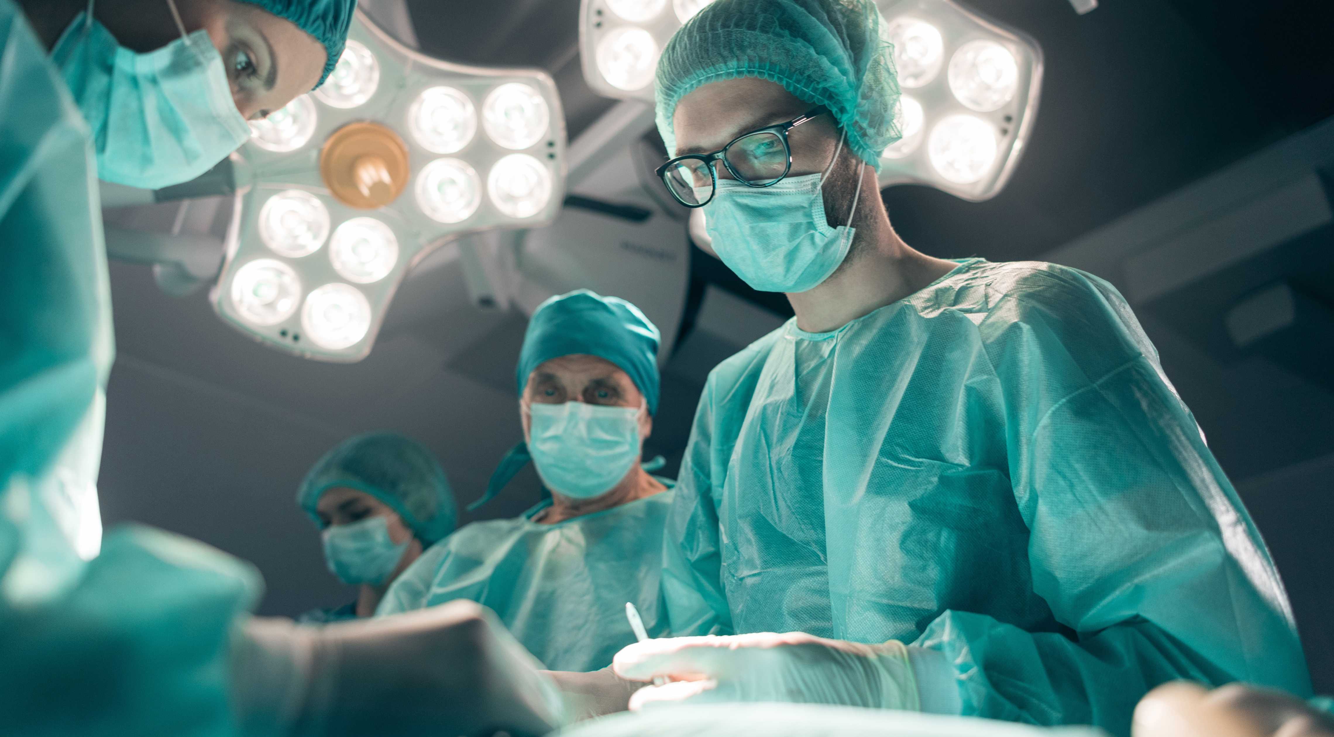 Copertina del caso di studio di UX design che mostra i chirurghi in sala operatoria con le luci in alto.